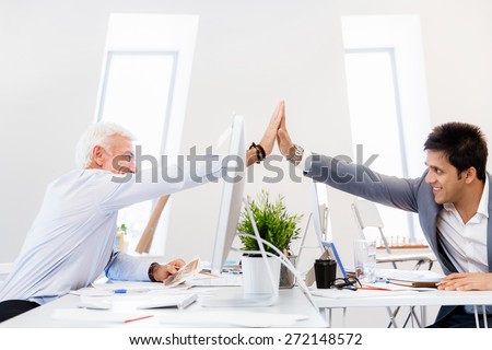 Businessmen in office cheering at their success