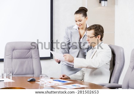 Young attractive secretary showing boss business documents