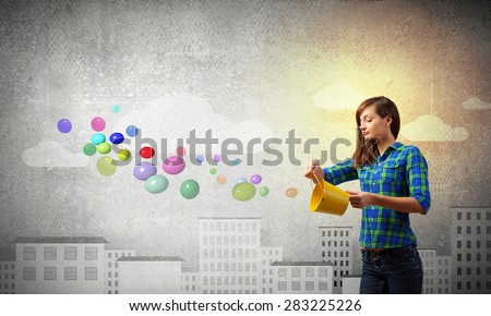 Young pretty woman with yellow bucket in hands