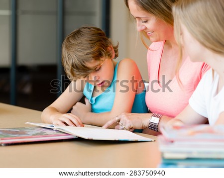 Mother with kids in library with books
