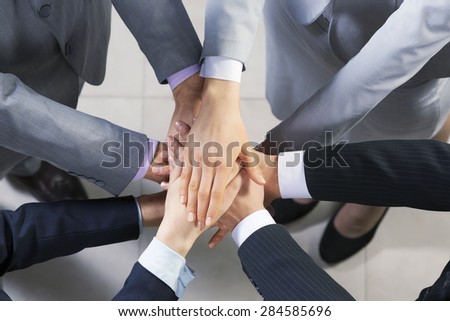 Close up of business peoples hands on top of each other