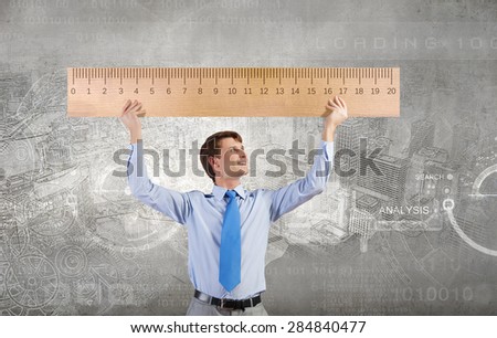 Young businessman holding in hands huge ruler