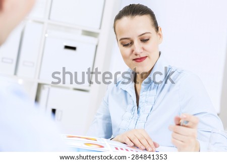 Businessman and businesswoman in office sitting at table and having conversation