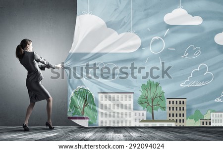 Young pretty businesswoman pulling clothing banner with city scene
