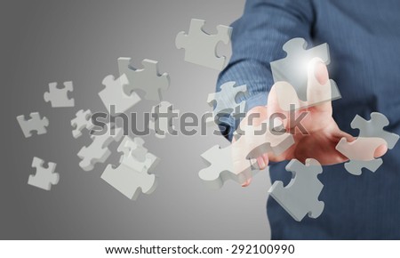Close up of businessman\'s hand touching abstract puzzle piece