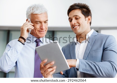 Two businessman in office with devices