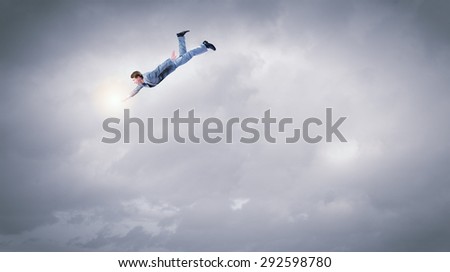 Happy young man dreaming to fly in sky