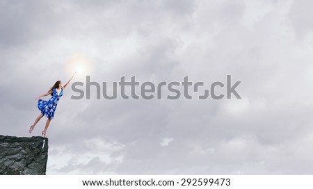 Happy young woman dreaming to fly in sky