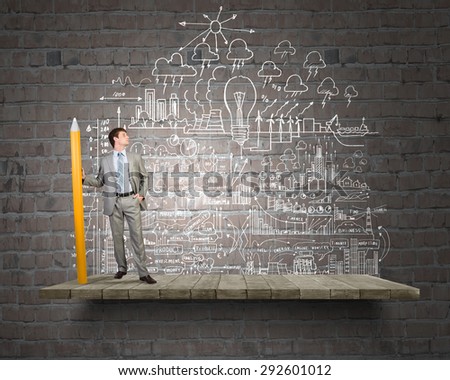 Businessman drawing plan strategy success with huge pencil