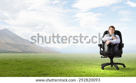 Young depressed businessman sitting in chair isolated from world