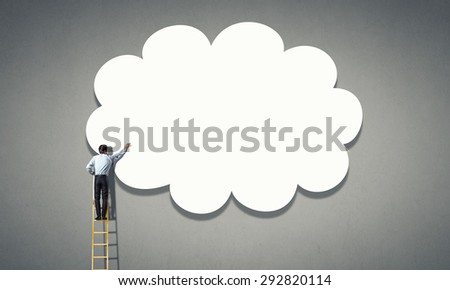 Back view of businessman standing on ladder and reaching to cloud