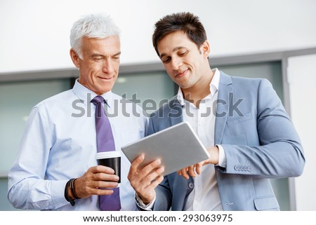 Two businessman in office with devices