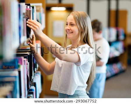 teenage girl in library choosing books