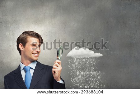 Businessman in suit looking through magnifying glass