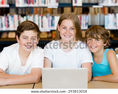 Three kids in library with notebook
