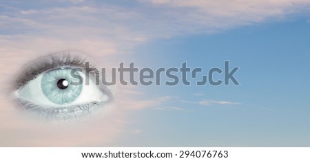 Close up of female eye on blue sky background