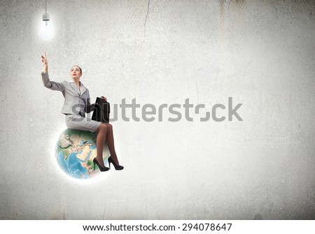 Happiness businesswoman sit on top of Earth planet. Elements of this image are furnished by NASA