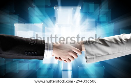 Close up of business handshake on digital background