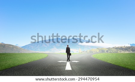 Back view of businessman standing at crossroads and making choice