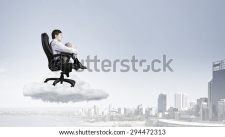 Young depressed businessman sitting in chair isolated from world