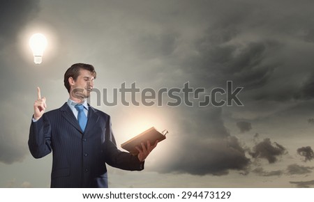 Young handsome man in suit reading old book