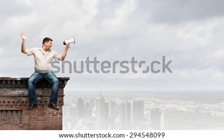 Fat man sitting on roof edge and screaming in megaphone