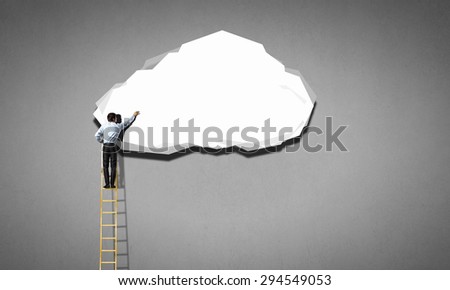 Back view of businessman standing on ladder and reaching to cloud
