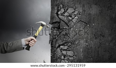 Close up of hammer in hand breaking cement wall