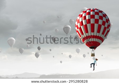 Businesswoman flying in search of ideas hanging on balloon