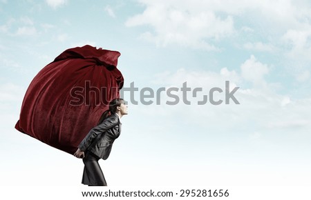Businesswoman carrying big heavy bag on back