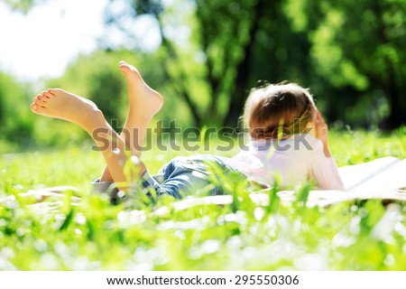 Child lying on blanket having picnic in summer park