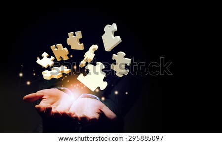 Close up of businessman holding jigsaw elements in palm