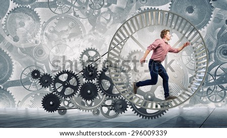 Young businessman running in wheel of gears mechanism