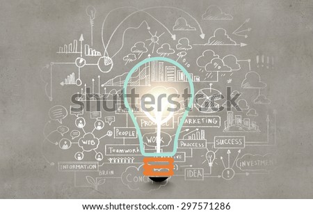 Conceptual image of light bulb on wall with sketches of ideas