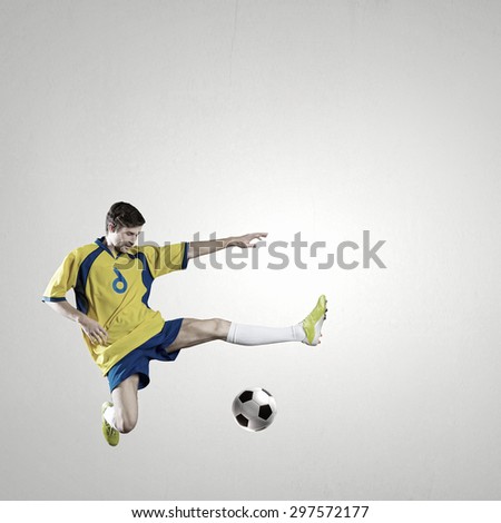 Soccer player kicking ball isolated over white background