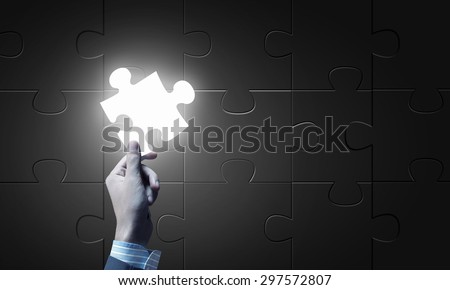 Close up of businessman hand holding glowing jigsaw element