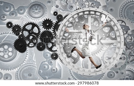 Young businesswoman running in wheel of gears mechanism