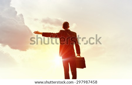 Rear view of businessman look at sunrise above city