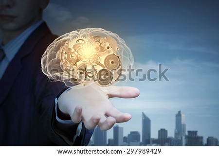 Close up of businessman holding human brain with working gears