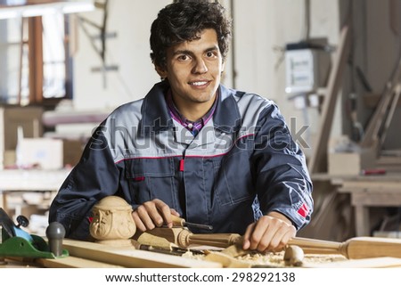 Young carpenter working with cutter in his studio