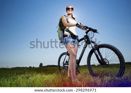 Low angle of young beautiful woman riding a bicycle in a park