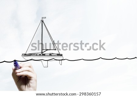 Close up of businessman hand drawing yacht with marker