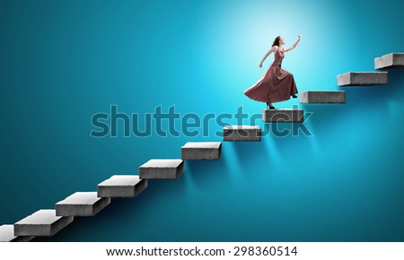 Young woman in evening long dress walking up the staircase