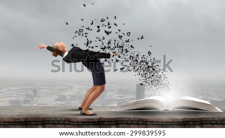 Young woman benting to evade characters flying from book