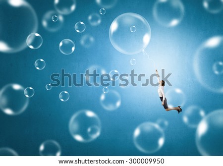 Young businesswoman flying high in sky on soap bubble