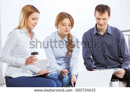 Three co-workers discussing business ideas in office