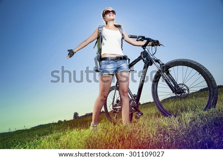 Low angle of young beautiful woman riding a bicycle in a park