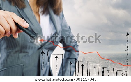 Chest view of businesswoman drawing with pencil increasing graph
