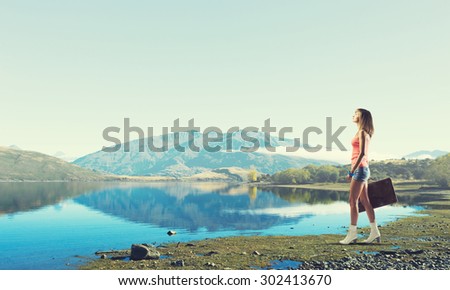 Traveler woman walking with retro suitcase in hand