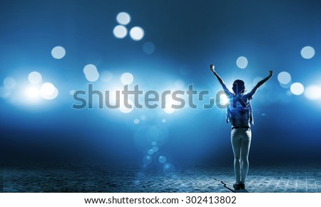 Back view of girl standing in stage lights